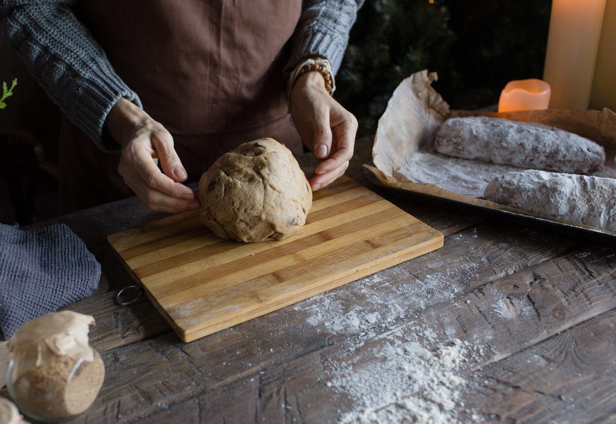 Close-up of hands kneading dough on a wooden board